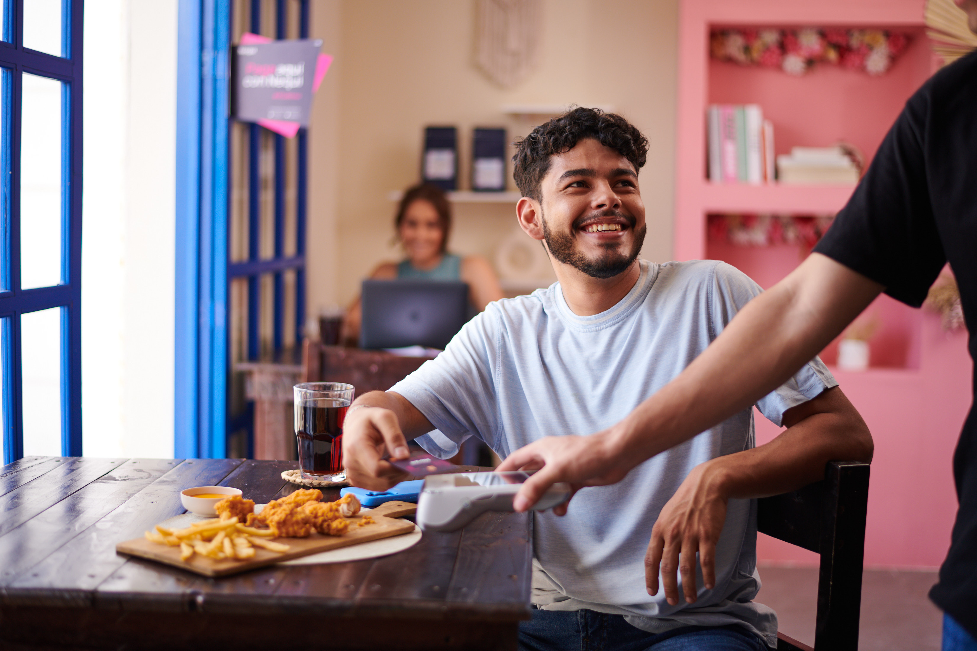 Persona utilizando su tarjeta física Nequi en un comercio